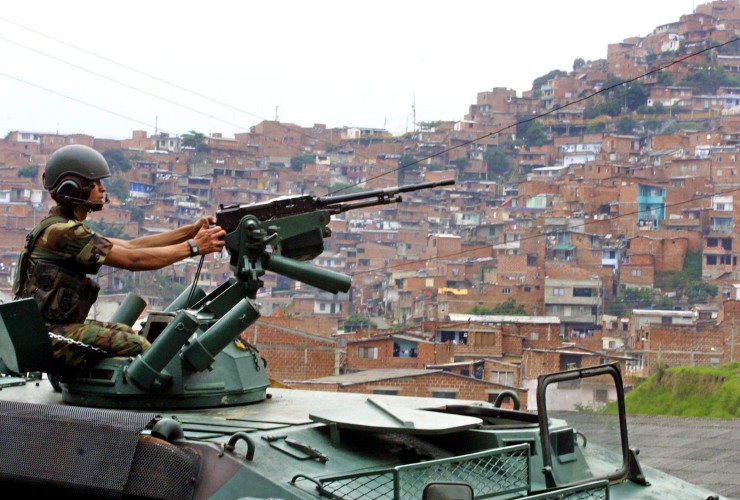 A government soldier sits atop a tank 18 October 2002 keeping a watchful eye over Comuna 13, a neighborhood of Medellin, Colombia©s second largest city. Medellin was rocked by violence since the government©s decision two months ago to recapture a sector of the city disputed by right-wing paramilitaries and militias. Fifteen people were killed and 20 were injured in Operation Orion ordered 16 October by President Alvaro Uribe. EPA PHOTO AFPI / FERNANDO VERGARA /ra/dc/EH